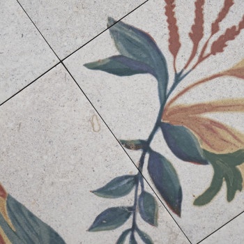 Keramische tegels hebben een bloemmotief met groene bladeren en rode bloemen. Het patroon strekt zich uit over vier verbonden te