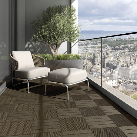 Ein Korbsessel und eine Ottomane stehen auf einem geometrisch gemusterten Balkon mit Blick auf eine weitläufige Stadtlandschaft Ein Korbsessel und eine Ottomane stehen auf einem geometrisch gemusterten Balkon mit Blick auf eine weitläufige Stadtlandschaft