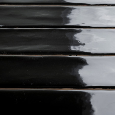 Glänzend schwarze Keramikfliesen reflektieren das Licht und erzeugen eine glänzende Oberfläche. Die Fliesen sind in parallelen R Glänzend schwarze Keramikfliesen reflektieren das Licht und erzeugen eine glänzende Oberfläche. Die Fliesen sind in parallelen R