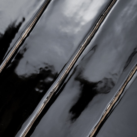 Les carreaux noirs élégants et brillants reflètent la lumière, créant des distorsions ondulées et capturant des reflets abstrait