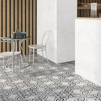 La escena de una cafetería presenta un piso de azulejos estampadas con diseños arremolinados en blanco y negro. Sillas blancas y