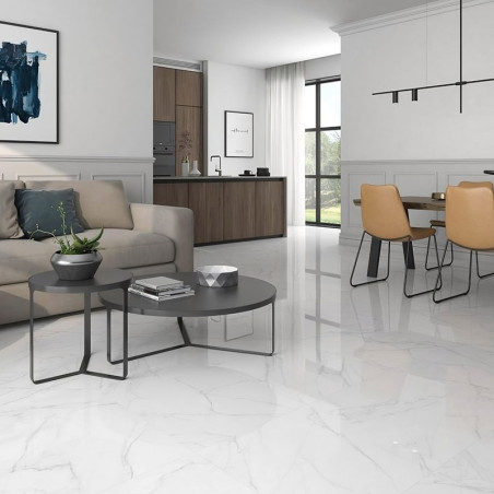 A glossy, white marble tile floor reflects light in a modern living and dining area, featuring a sofa, round tables, and mustard
