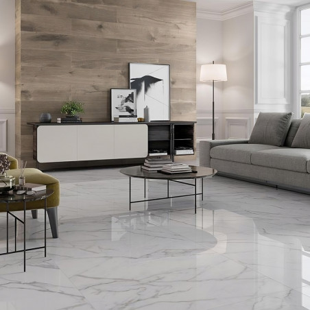 Glossy white marble tiles cover the floor, reflecting light in a modern living room with a gray sofa and wooden accents.