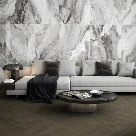 Een moderne woonkamer is voorzien van een lichtgrijze sofa versierd met donkere kussens. Ervoor staat een strakke tafel met tijd Een moderne woonkamer is voorzien van een lichtgrijze sofa versierd met donkere kussens. Ervoor staat een strakke tafel met tijd