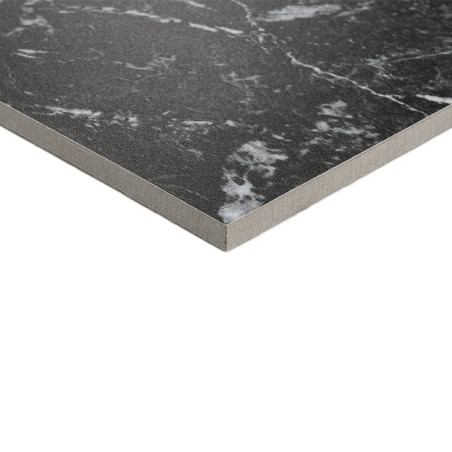 Un carreau carré présente une surface gris foncé avec des veines blanches, ressemblant à du marbre. Il repose sur un fond plat e