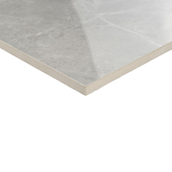 Un azulejo cerámico gris liso, reposado, con sutiles vetas marmóreas. Está colocado sobre un fondo blanco liso.