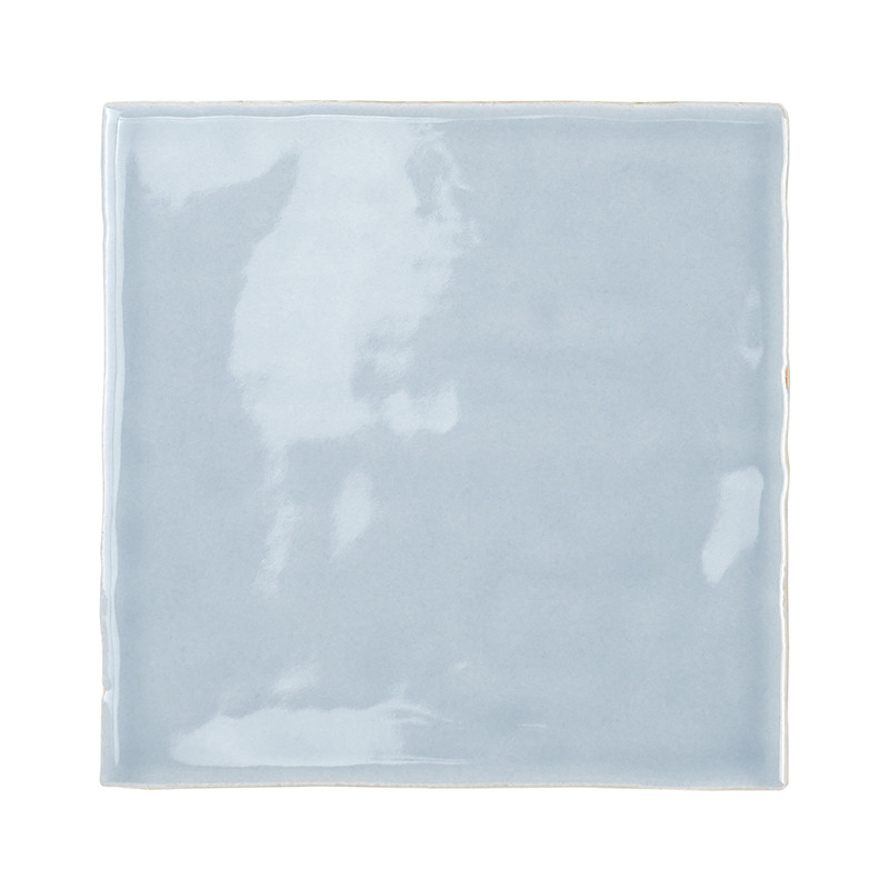 Un azulejo cerámico cuadrado, de color azul claro brillante, refleja la luz, creando patrones sutiles. liso y uniforme, se apoya