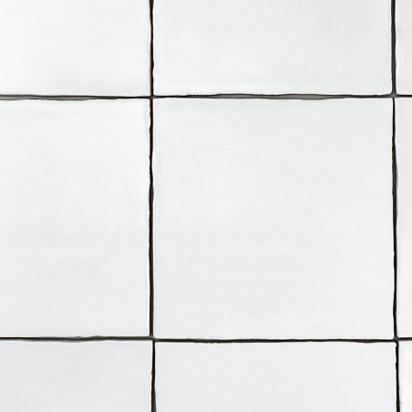 Des carreaux carrés blancs disposés selon un motif en grille, séparés par de fines lignes de coulis sombres, forment une surface