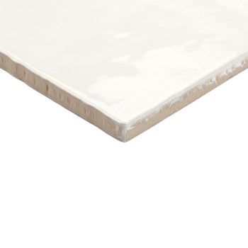 Un azulejo cerámico cuadrada muestra un acabado blanco brillante con bordes beige ligeramente ásperos, descansando sobre un fond