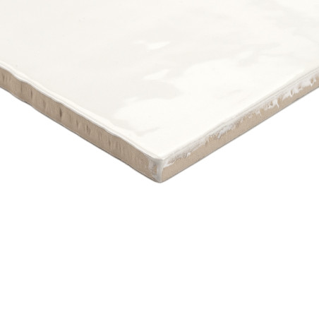 Un azulejo cerámico cuadrada muestra un acabado blanco brillante con bordes beige ligeramente ásperos, descansando sobre un fond