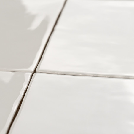 Quatro ladrilhos de cerâmica brancos e brilhantes formam uma grade, unidos por finas linhas de argamassa, refletindo a luz em um Quatro ladrilhos de cerâmica brancos e brilhantes formam uma grade, unidos por finas linhas de argamassa, refletindo a luz em um