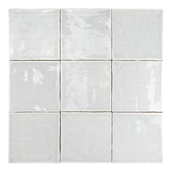 Un carreau de céramique blanc, lisse et brillant, repose à plat, réfléchissant subtilement la lumière, entouré d’un fond blanc u