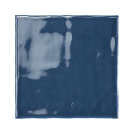 Eine glänzende, dunkelblaue Keramikfliese reflektiert Licht und zeigt Schattierungen und Streifen auf ihrer glatten Oberfläche v