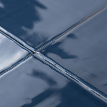 Blauwe keramische tegels met een glanzende afwerking reflecteren het licht, waardoor een glad, glanzend oppervlak ontstaat. Grou
