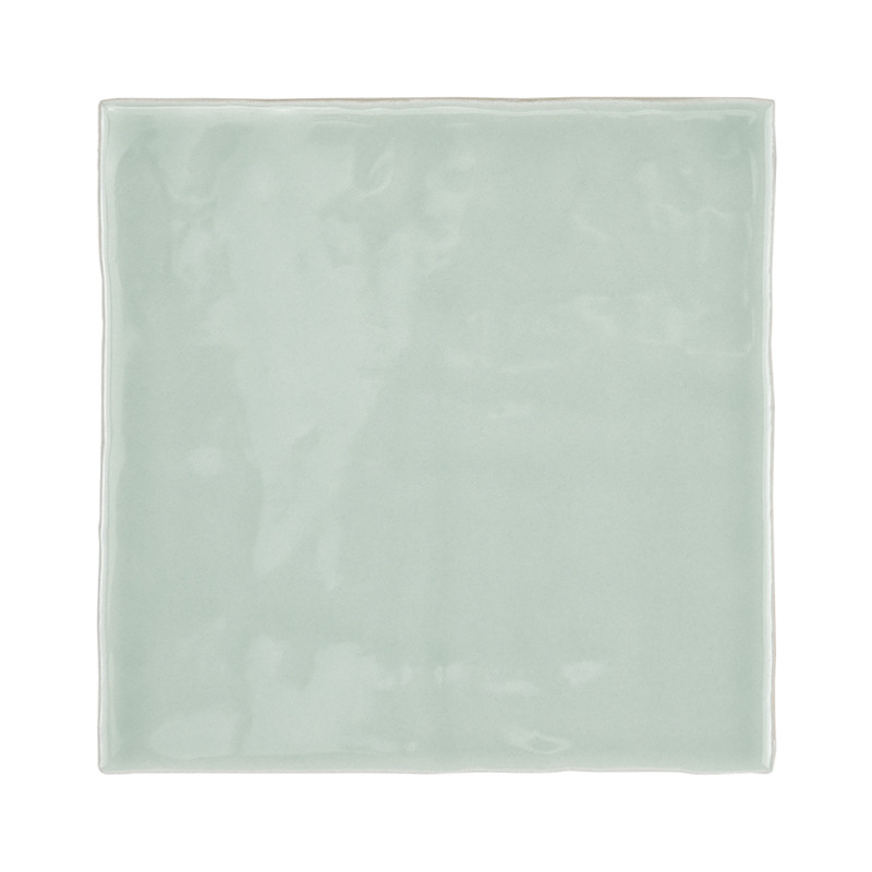 Eine glatte, glänzende, hellgrüne quadratische Fliese reflektiert das Licht subtil und zeigt eine minimalistische, moderne Ästhe