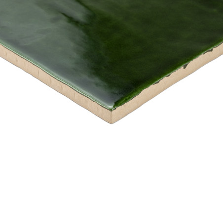 Um revestimento cerâmico verde escuro brilhante é mostrado com uma superfície lisa e bordas bege, contra um fundo branco liso. Um revestimento cerâmico verde escuro brilhante é mostrado com uma superfície lisa e bordas bege, contra um fundo branco liso.