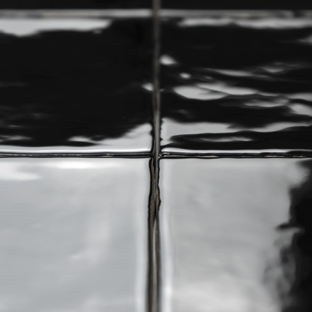 Glänzend schwarze Fliesen verbinden sich nahtlos, reflektieren das Licht in Wellen und sorgen so für ein elegantes, modernes Ers Glänzend schwarze Fliesen verbinden sich nahtlos, reflektieren das Licht in Wellen und sorgen so für ein elegantes, modernes Ers