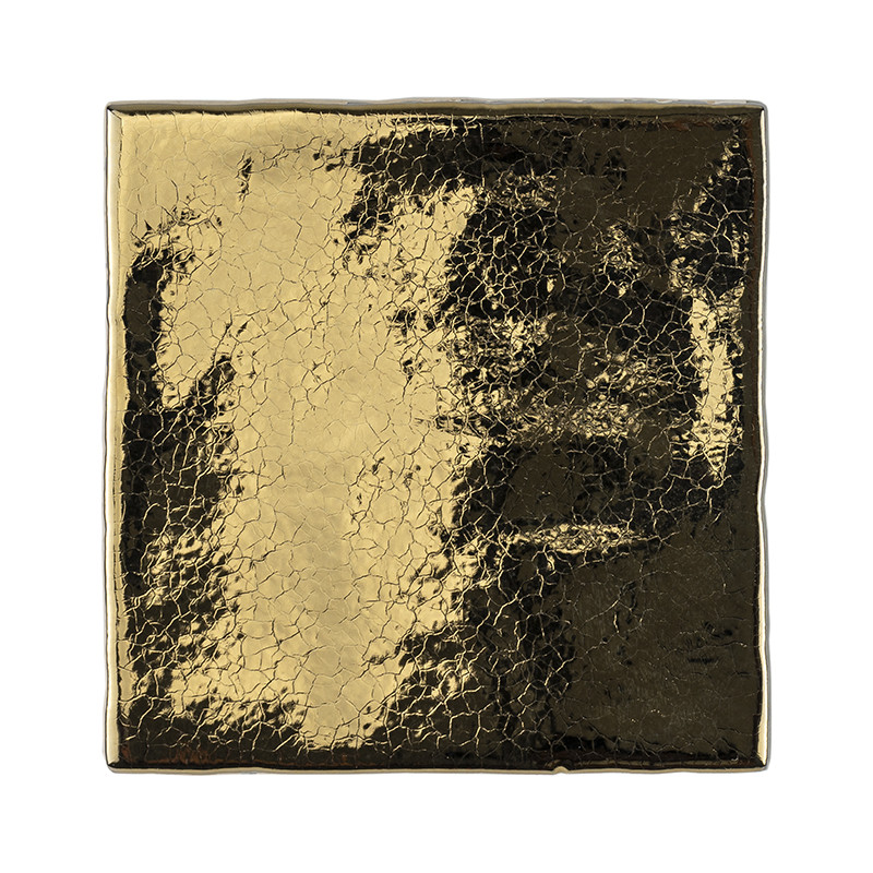 Un carreau carré présente une surface dorée réfléchissante et craquelée, créant un effet texturé et vieilli dans un cadre minima