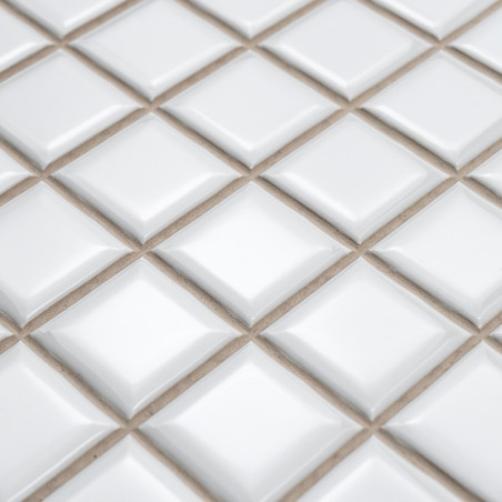 azulejos cerámicos cuadradas dispuestas en forma de diamante con superficies elevadas, creando un efecto tridimensional texturiz