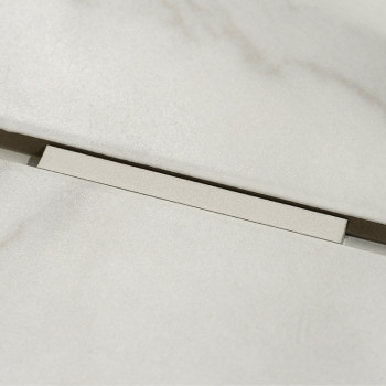 A light beige rectangular tile rests slightly elevated against a matching background, revealing a narrow dark gap beneath it.