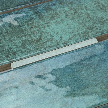 Les carreaux de céramique verts et bleus présentent une surface texturée réfléchissant la lumière. Il est disposé contextuelleme