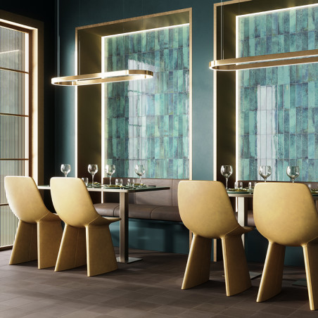 Cadeiras amarelas cercam uma mesa de jantar elegante com vidros em uma sala moderna com paredes de azulejos verdes e iluminação 