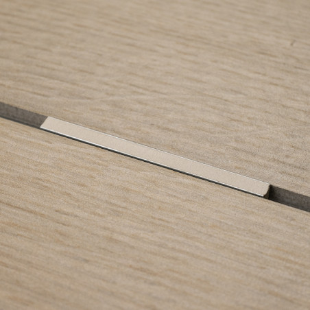 Un carreau beige à texture de bois repose à plat avec une étroite bande métallique encastrée dans une rainure centrale, contre u Un carreau beige à texture de bois repose à plat avec une étroite bande métallique encastrée dans une rainure centrale, contre u