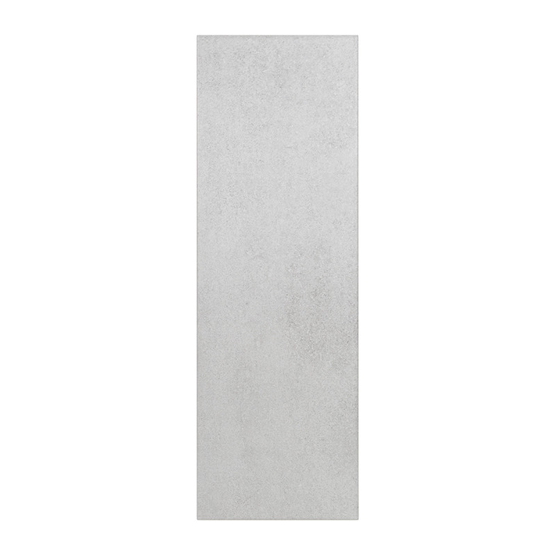 El azulejo es rectangular con una superficie lisa, mate y de color gris claro, adecuado para instalaciones en pisos o paredes en
