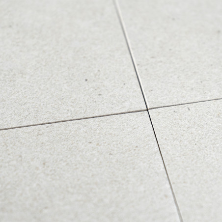 Quatre carreaux de céramique gris clair se croisent à leurs coins, formant un motif en croix. La surface présente une finition s