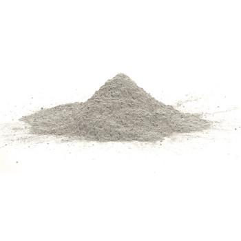 Un pequeño montículo de polvo fino y gris se asienta sobre una superficie blanca, distribuido uniformemente en un ambiente inter