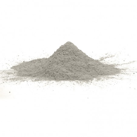 Una pila cónica de polvo fino y gris descansa sobre una superficie blanca y plana, extendiéndose ligeramente hacia afuera.